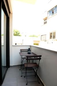 a table and chairs on a balcony with a window at King George Apartments in Tel Aviv