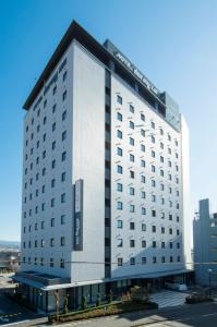 a large white hotel building with a lot of windows at Dormy Inn Mishima in Mishima
