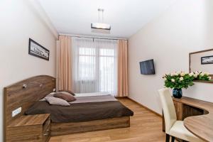 - une chambre avec un lit, une table et une fenêtre dans l'établissement Gold - Neptun Park by OneApartments, à Gdańsk