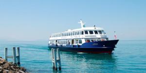 a large boat in the water next to a dock at Royal Standing- Terrasse & Parking Privé in Évian-les-Bains