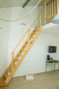 escalera de madera en una habitación blanca con mesa en Casa das Pipas #2 en Pinhal Novo