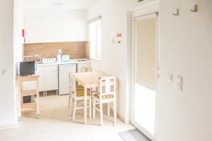 Il comprend une petite cuisine avec une table et des chaises en bois. dans l'établissement Casa das Pipas #2, à Pinhal Novo