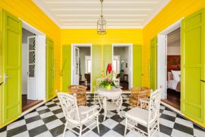 une salle à manger avec des murs jaunes, une table et des chaises dans l'établissement Villa Marie Lucie, à Saint-Denis