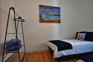 Habitación con cama y pintura en la pared en Casa Joana B&B, en Cascais