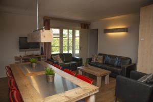 a living room with a table and a couch at Wilbrink 6-8 pers. bungalow in Voorthuizen