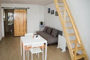 sala de estar con sofá, mesa y escalera en Casa das Pipas #6, en Pinhal Novo