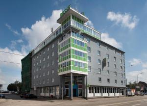 a tall gray building with green windows on a street at ibis Styles Halle in Halle an der Saale
