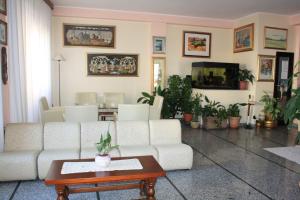 a living room with a white couch and a table at Hotel Grillo in Nuoro