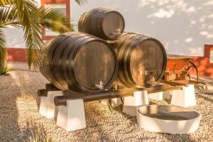 trois tonneaux de vin en bois exposés à côté d'un bâtiment dans l'établissement Casa das Pipas Palmela #6, à Pinhal Novo