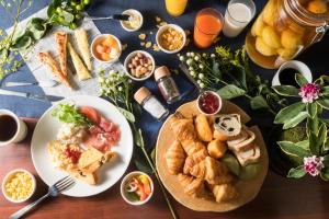 una mesa cubierta con platos de comida y otros alimentos en the b kobe, en Kobe