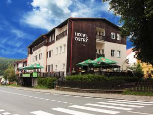 a hotel with green umbrellas in front of a building at Apartmány hotelu Ostrý in Železná Ruda