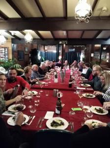 The Coachman Ski Lodge في Smiggin Holes: مجموعة كبيرة من الناس يجلسون على طاولة طويلة