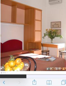 ローディ・ガルガーニコにあるレジデンス ドゥカーレのテーブルとフルーツの盛り合わせが備わる部屋