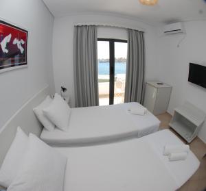 2 Betten in einem Zimmer mit Meerblick in der Unterkunft Hotel MS in Sarandë