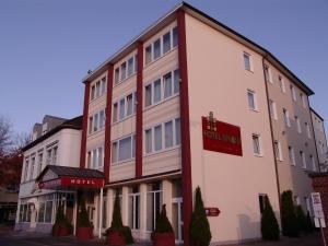 a hotel with a red sign on the side of a building at Hotel Sprenz in Oldenburg