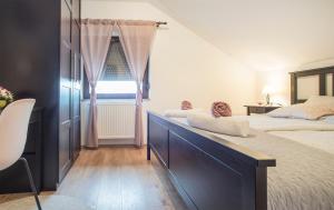 1 dormitorio con 2 camas y ventana en Holiday Home Dandelion with Hot Tub & Sauna, en Cetingrad