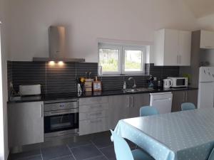 a kitchen with stainless steel appliances and a table at Villa Ricardo in Alcobaça
