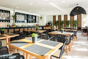 an empty restaurant with wooden tables and chairs at Nostos Beach Boutique Hotel in Bali