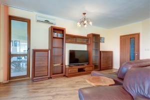 a living room with a couch and a television at ДриймБг Апартаменти - Панорама Бийч, Несебър in Nesebar +12 photos