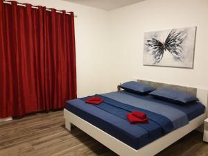 a bedroom with a bed with blue sheets and red pillows at Dani in Zadar
