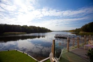 a view of a river with a dock and the water at The Boathouse in Rollesby