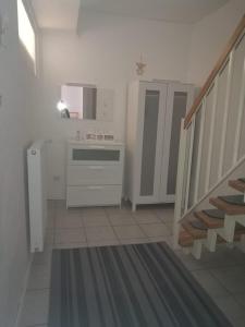 uma cozinha branca com uma escada e um lavatório em Ferienhaus Zoe 120 m2 em Solingen