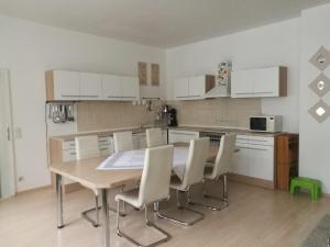 a kitchen with a wooden table and white cabinets at Ferienhaus Zoe 120 m2 in Solingen
