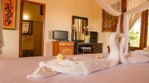 twee zwanen handdoeken liggen bovenop een bed bij Hotel Suma in Lovina