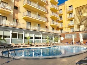 a swimming pool in front of a building at Hotel Stella Maris in Blanes