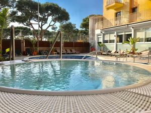 een zwembad met een glijbaan in het midden van een gebouw bij Hotel Stella Maris in Blanes