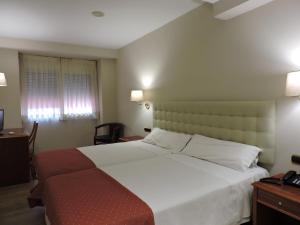 Postel nebo postele na pokoji v ubytování Hotel El Nogal
