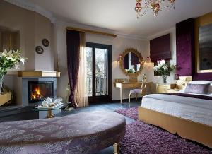 ein großes Schlafzimmer mit einem Bett und einem Kamin in der Unterkunft Stevalia Hotel & Spa in Portaria + 119 Fotos