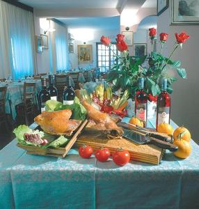 una mesa con verduras y botellas de vino. en Hotel Grillo en Nuoro