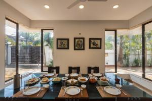 a dining room with a table with food on it at SaffronStays Vedanta, Lonavala - villa with lawn, plunge pool and indoor games near Tungarli Lake in Lonavala