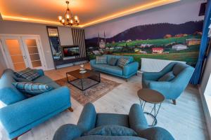 a living room with blue couches and a painting on the wall at BAHAR RESIDENCE in Trabzon