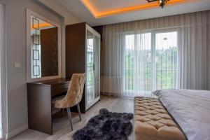 a bedroom with a desk and a bed and a chair at BAHAR RESIDENCE in Trabzon +68 photos