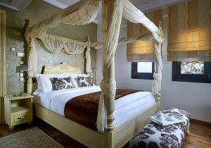 a bedroom with a bed with a canopy at Stevalia Hotel & Spa in Portariá
