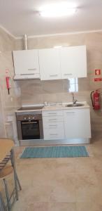 ポルトにあるMade in You - Oporto Roomsの白いキャビネットとシンク付きのキッチン