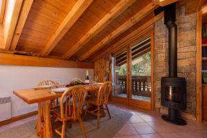 a dining room with a wood stove in a cabin at Village des Oursons Chalet B - Happy Rentals in Chamonix-Mont-Blanc