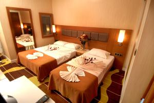two beds in a hotel room with flowers on them at Oba Star Hotel - Ultra All Inclusive in Alanya
