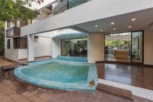 a swimming pool in the middle of a house at SaffronStays Vedanta, Lonavala - villa with lawn, plunge pool and indoor games near Tungarli Lake in Lonavala
