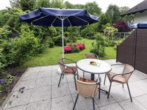 a table and chairs with an umbrella on a patio at Ferienwohnung Putbus in Güstelitz