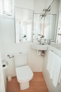 La salle de bains blanche est pourvue de toilettes et d'un lavabo. dans l'établissement CARABELA 92, à Alcúdia