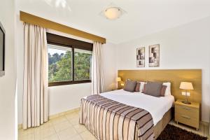 米哈斯的住宿－麥克唐納拉埃爾米塔度假酒店，一间卧室设有一张大床和一个窗户。