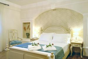 a bedroom with a large bed with towels on it at Stevalia Hotel & Spa in Portaria