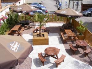 an outdoor patio with tables and chairs and umbrellas at The Harboro Hotel in Melton Mowbray