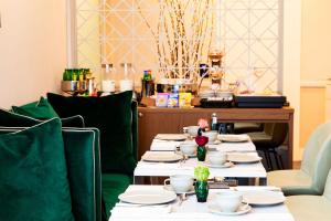 długi stół z talerzami i kubkami w obiekcie Amadomus Luxury Suites w mieście Napoli