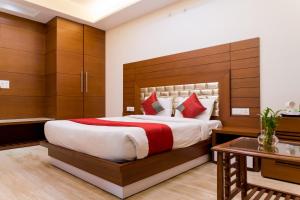 um quarto com uma cama grande e uma mesa em SM Palace (Near Apollo Hospital) em Nova Deli