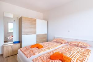 1 dormitorio con 1 cama grande y 2 almohadas de color naranja en Apartment SALE EL SOL, en Medulin