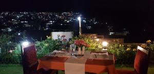 uma mesa de jantar com vista para a cidade à noite em Woodland Hill Stay em Shillong